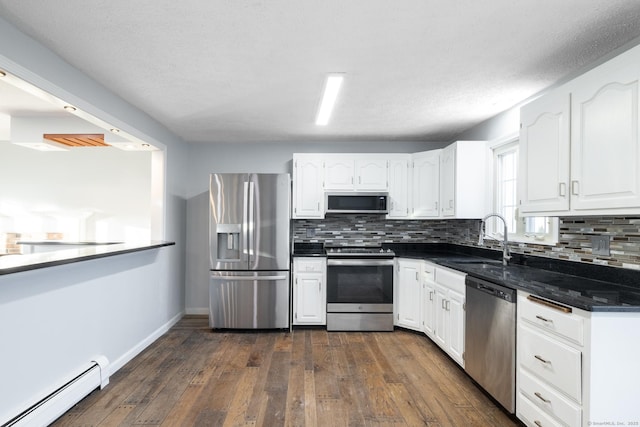 kitchen with tasteful backsplash, a baseboard heating unit, sink, and stainless steel appliances