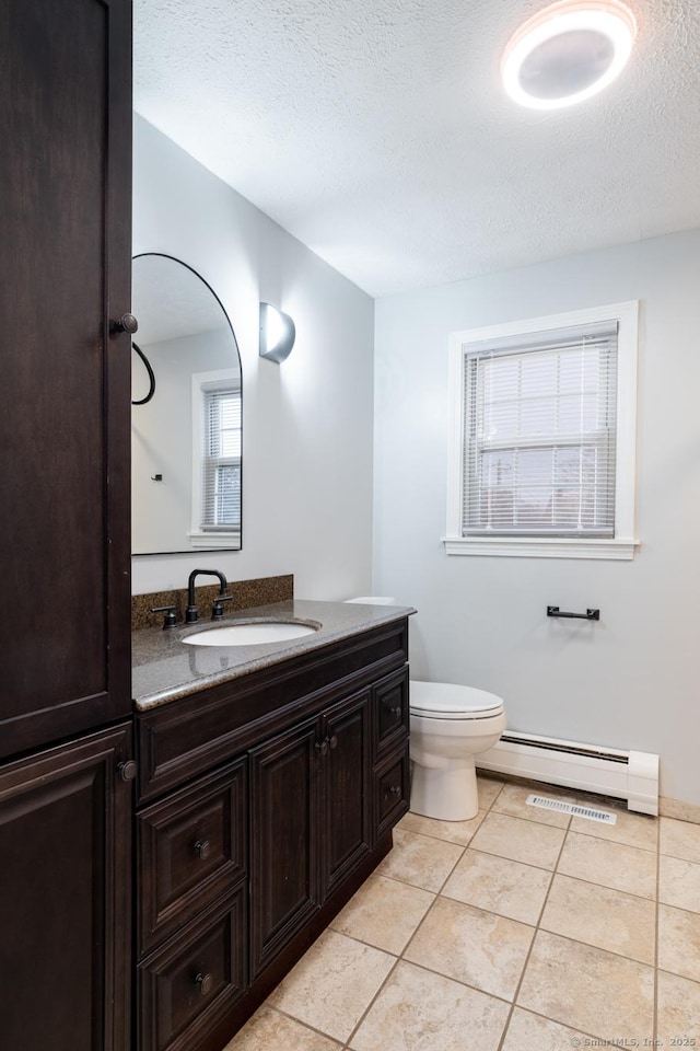 bathroom with toilet, baseboard heating, tile patterned flooring, a textured ceiling, and vanity