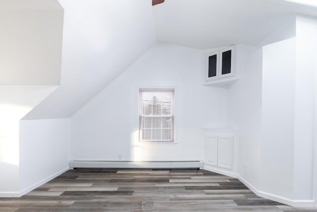 bonus room with a baseboard radiator, dark hardwood / wood-style floors, and vaulted ceiling