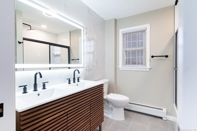 bathroom with toilet, vanity, tile patterned floors, a shower with shower door, and baseboard heating