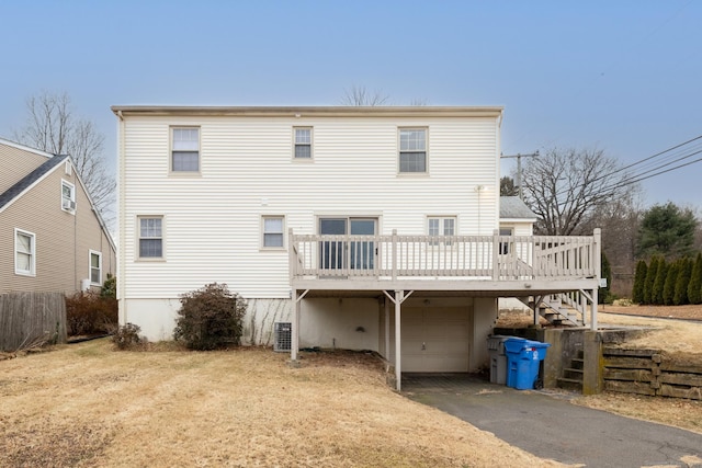 rear view of property with a garage, a deck, and central AC unit