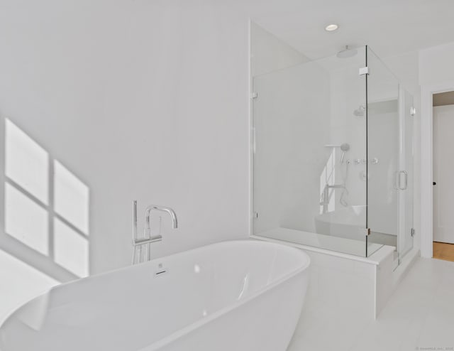 bathroom featuring shower with separate bathtub