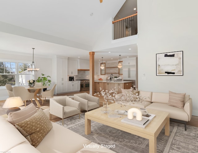 living room with sink, a high ceiling, and a notable chandelier