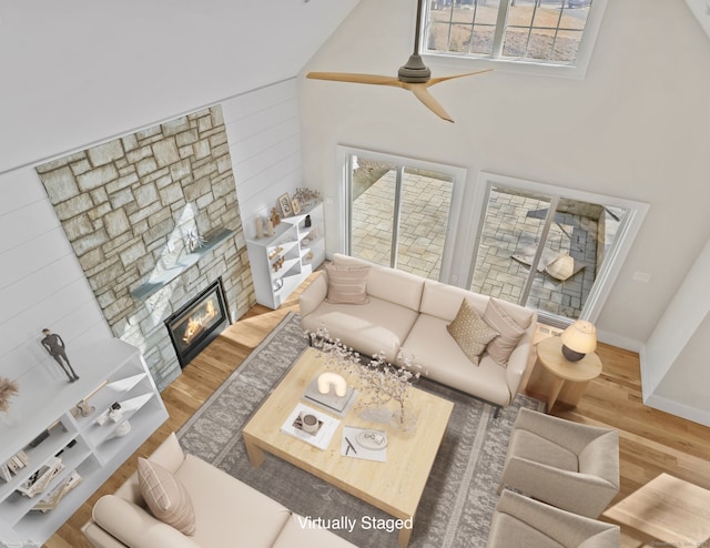 living room featuring ceiling fan, a healthy amount of sunlight, a fireplace, and hardwood / wood-style floors