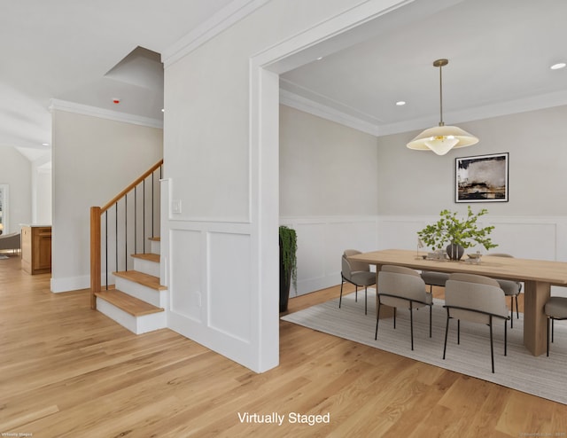 dining room with crown molding and light hardwood / wood-style flooring