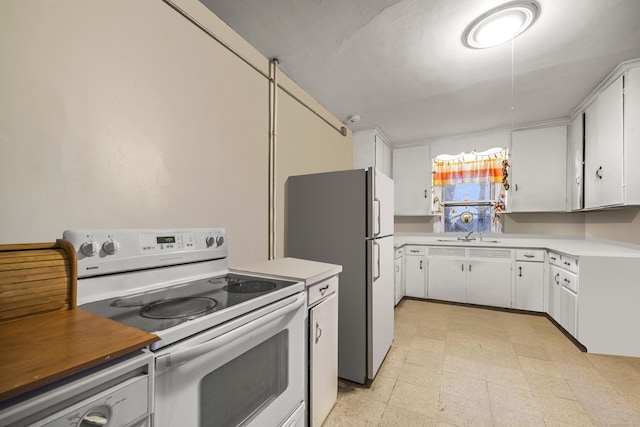 kitchen with white appliances, white cabinets, and sink