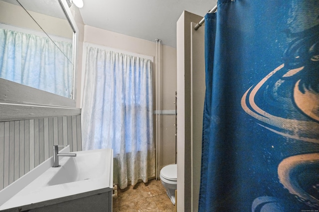 bathroom featuring toilet, curtained shower, and vanity