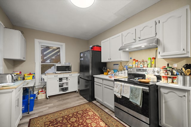 kitchen with white cabinets, appliances with stainless steel finishes, and light hardwood / wood-style floors