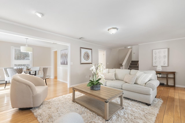 living room with crown molding and light hardwood / wood-style flooring