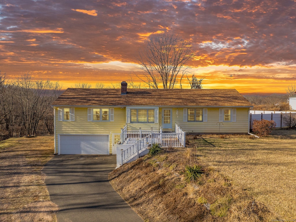 ranch-style home featuring a garage and a yard