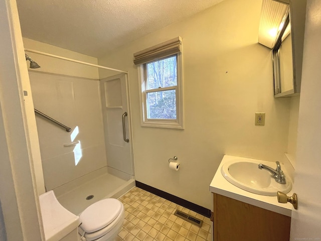 bathroom with walk in shower, vanity, a textured ceiling, and toilet