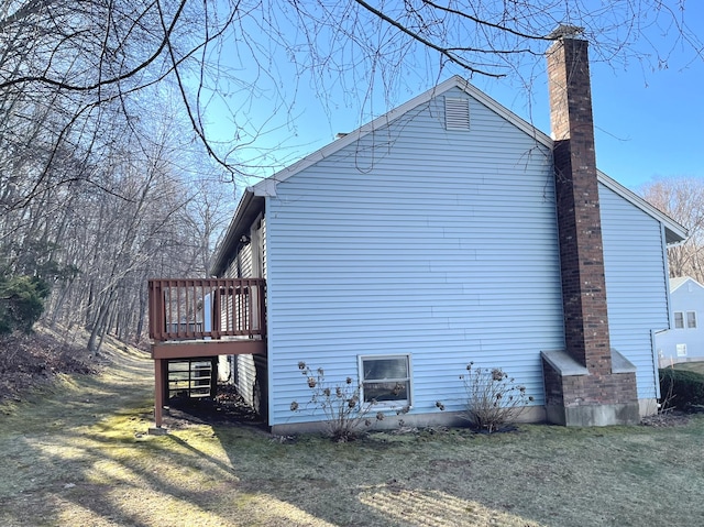 view of property exterior featuring a wooden deck and a yard