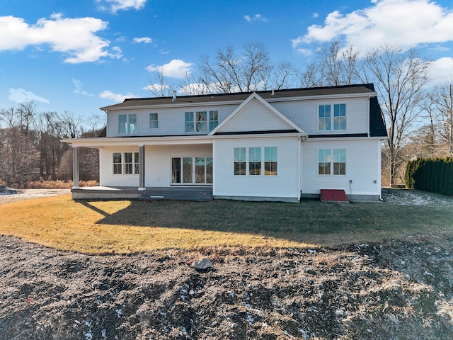 rear view of property featuring a lawn