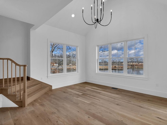 dining area featuring high vaulted ceiling, light hardwood / wood-style floors, and a notable chandelier