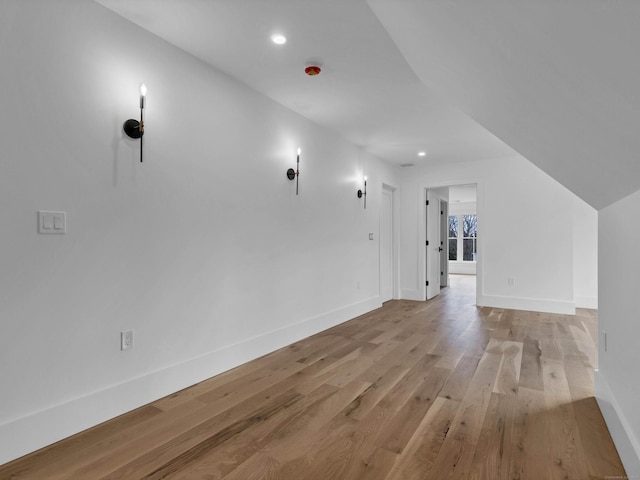 additional living space with lofted ceiling and light hardwood / wood-style floors