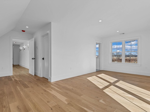 unfurnished room featuring vaulted ceiling and light wood-type flooring