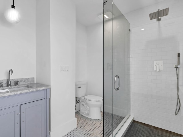 bathroom with tile patterned flooring, vanity, toilet, and a shower with shower door