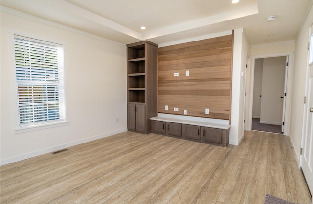 unfurnished living room featuring light hardwood / wood-style floors and a raised ceiling