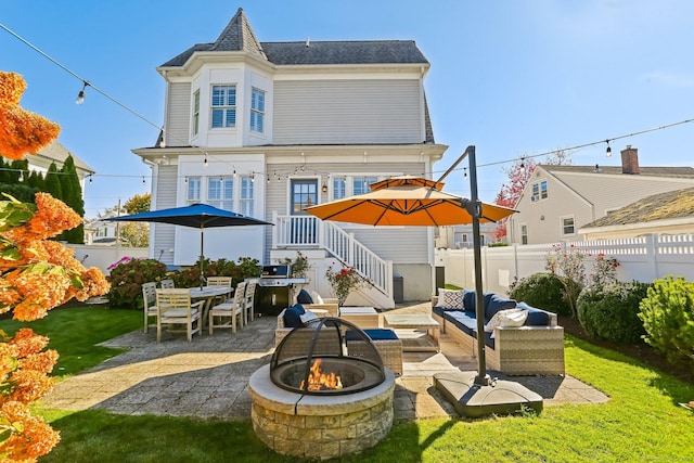 back of house with a yard, an outdoor living space with a fire pit, and a patio