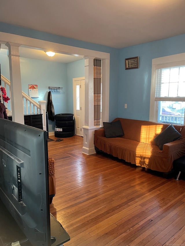 living room with wood-type flooring and decorative columns