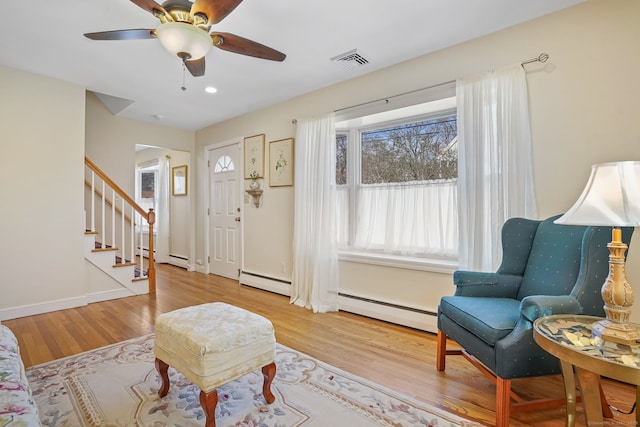 foyer featuring wood finished floors, visible vents, a baseboard radiator, stairs, and a baseboard heating unit