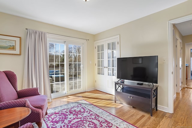 interior space featuring french doors, baseboards, and wood finished floors