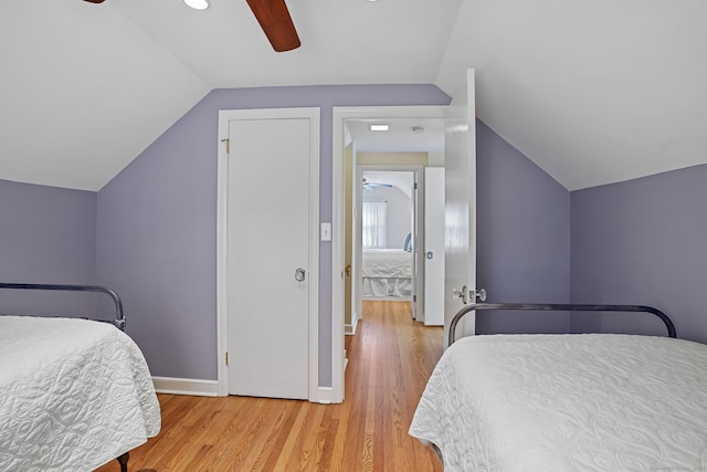 bedroom featuring baseboards, a ceiling fan, light wood-style floors, and vaulted ceiling