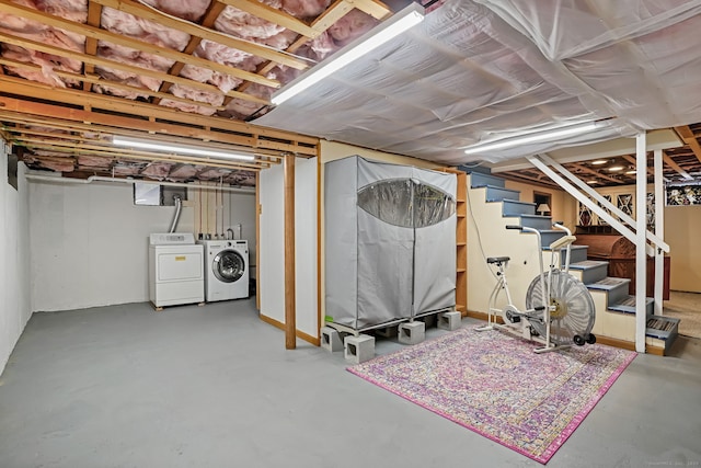 unfinished basement featuring washer and clothes dryer and stairs