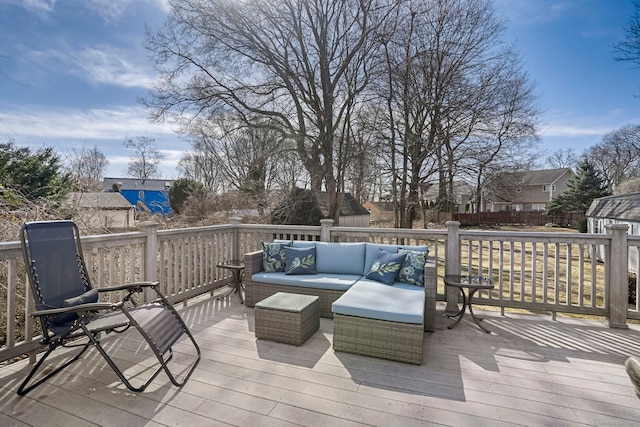 wooden terrace with an outdoor hangout area and fence