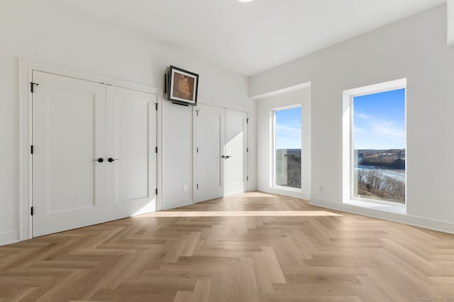 interior space with light parquet flooring and a water view