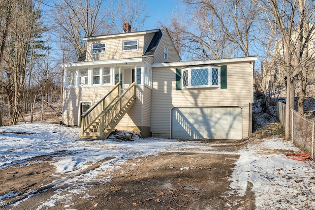 snow covered rear of property with a garage