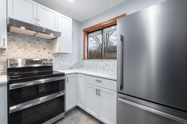 kitchen featuring decorative backsplash, white cabinets, and appliances with stainless steel finishes