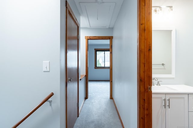 corridor featuring light carpet and sink