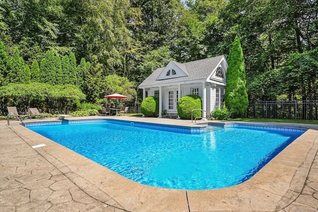 view of pool featuring a patio area, a diving board, and an outdoor structure