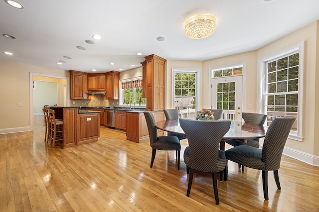 dining area featuring light wood-type flooring and sink