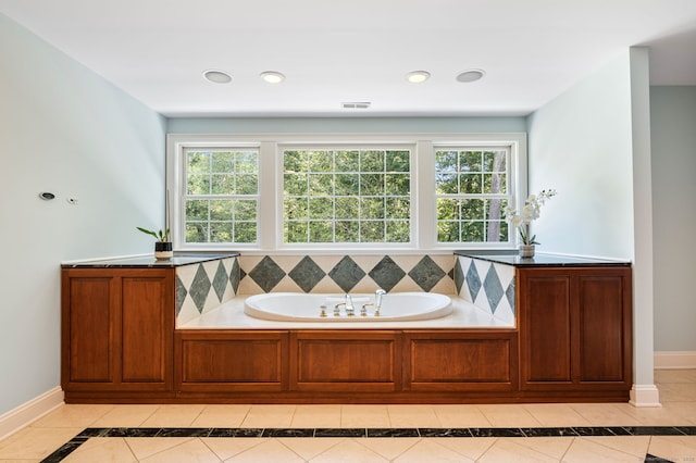 bathroom with tile patterned flooring, plenty of natural light, and a bath