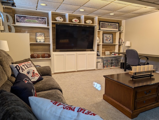 living area featuring a paneled ceiling and carpet