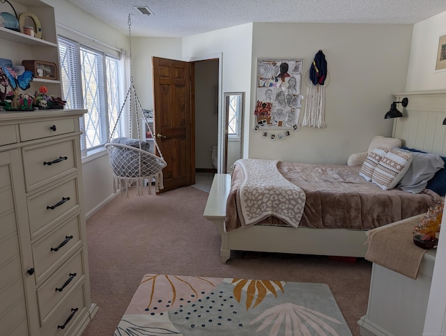 bedroom with visible vents, light carpet, and a textured ceiling