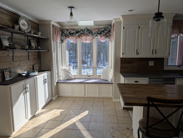 kitchen featuring light tile patterned floors, butcher block counters, white cabinetry, and decorative light fixtures