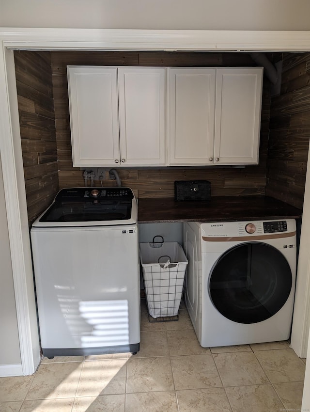 washroom featuring light tile patterned floors, cabinet space, and independent washer and dryer