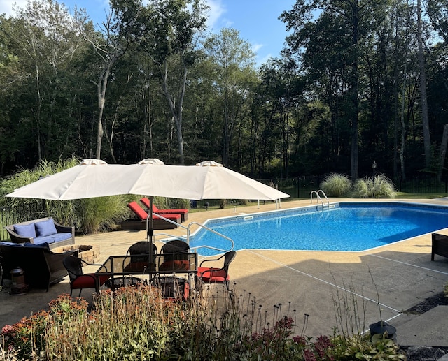 pool featuring an outdoor living space and a patio area