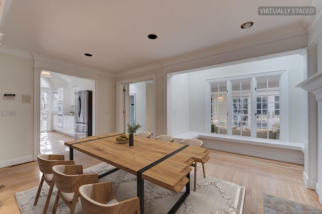 dining area featuring light wood-style flooring and ornamental molding