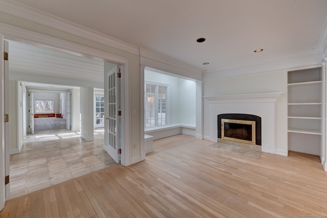 unfurnished living room featuring french doors, light hardwood / wood-style floors, and crown molding