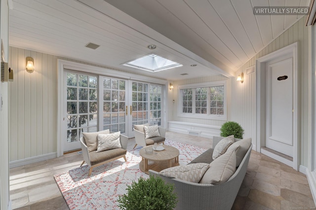 sunroom with a skylight, french doors, wooden walls, and a healthy amount of sunlight