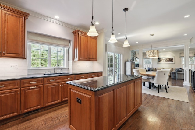 kitchen with a center island, decorative light fixtures, decorative backsplash, dark hardwood / wood-style flooring, and sink