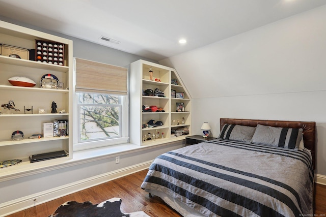 bedroom with vaulted ceiling and dark hardwood / wood-style floors