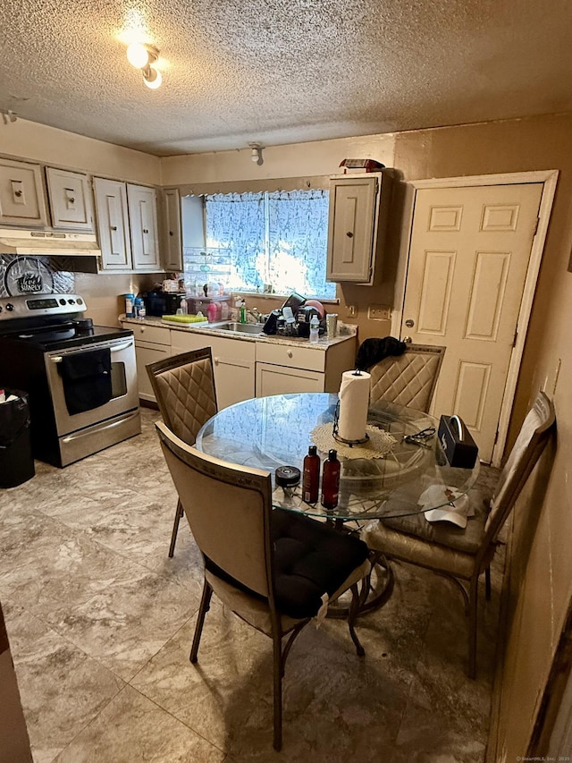 kitchen with a textured ceiling, stainless steel electric range oven, and sink