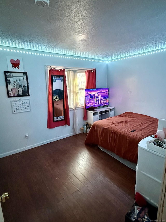 bedroom with hardwood / wood-style flooring and a textured ceiling