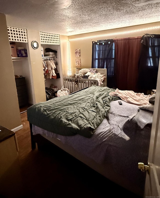 bedroom featuring hardwood / wood-style floors, a textured ceiling, and a closet