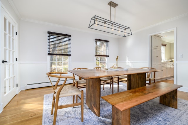 dining space featuring baseboard heating, light wood-type flooring, and ornamental molding